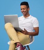 stock photo of a man smiling while working on a laptop