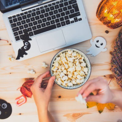 Stock image of a hand in front of a keyboard with small Halloween decorations