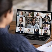 stock photo looking over a man's shoulder at a Zoom meeting